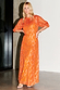 Orange Jacquard Bibi Dress with gold metallic threads and puffball sleeves on a model.