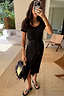 Black Jesse Jersey Wrap Dress in cotton with a tee-style top and adjustable wrap tie, shown in a mirror selfie.