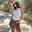 White Cowgirl Tank in ribbed fabric with gold graphics, styled with a brown bandana skirt in a sunny setting.