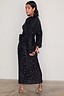 Thumbnail for Black Sequin Kira Wrap Dress with long sleeves and a tie waist, shown on a model wearing animal print heels.