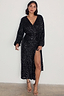 Thumbnail for Black Sequin Kira Wrap Dress featuring a multi-wear wrap style, long sleeves, and a leg slit on a model.