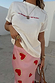 Pink Hearts Dorris midaxi skirt with gold-bordered red heart motifs, styled with a white t-shirt. Model is 5ft6, size 8.