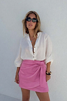 Iconic Pink Vegan Leather Mini Jaspre Skirt styled with a white shirt and dark sunglasses.