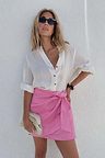 Pink Vegan Leather Mini Jaspre Skirt styled with a white button-down shirt and sunglasses.