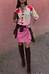 Iconic Pink Vegan Leather Mini Jaspre Skirt styled with a patterned cardigan and brown knee-high boots.