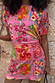 Pink Fruit Stamps Mini Dress with a fruit motif and t-shirt silhouette, styled against a textured stone wall.