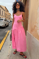 Pink Strappy Nova Dress featuring a dropped waist and full midaxi skirt, styled on a city street for a vacation look.