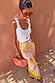 Pink Fawn Poppy Midi Maeva Skirt with yellow floral print and contrast lace trim, styled for a summer vacation.