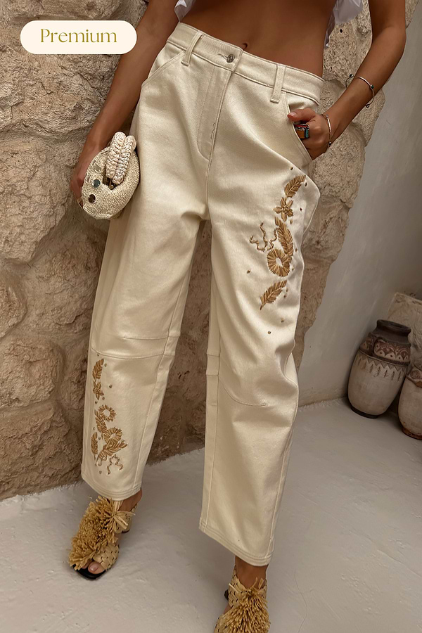 Ecru Raffia Palma Barrel Leg Jeans featuring brown floral raffia embroidery on a cream denim base.
