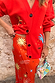Red Celestial Dorris Skirt in satin with hand-painted sun motifs, styled with a matching red cardigan.