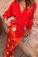 Red Celestial Dorris Skirt in red satin featuring celestial motifs, styled with a matching cardigan and beaded bag.