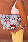 Light blue detachable pouch with sun faces and swirl prints, held by a model wearing a white tank and gold bangles.
