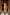 Thumbnail for Rio A-Symmetric Skirt in a vibrant fruit print, styled as a co-ord with a matching top in a rustic doorway.