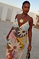 Abstract Soleil Emilia Dress featuring pastel sun motif panels and a V-neckline, styled for a sunny vacation.