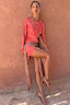 Thumbnail for Spliced Fawn Mini Nola Tie Dress in red and brown spotted prints, worn by a model against a terracotta wall.