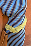 Thumbnail for Stripe A-Symmetrical Top with blue and navy diagonal stripes and a yellow lace-trimmed hem, styled with a tan bag.