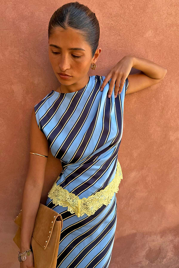 Stripe A-Symmetrical Top featuring blue diagonal stripes and yellow lace trim, styled on a model.