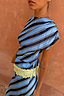 Stripe A-Symmetrical Top with blue diagonal stripes and a cream lace hem on a model against a peach wall.