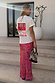 White Rodeo T-Shirt with a red graphic print on the back, styled with a pink paisley skirt and a woven bag.