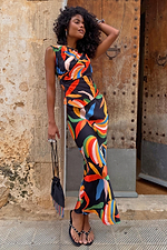 Banana Dorris Skirt in a multicoloured hand-painted banana print on black jersey, styled as a co-ord against a stone wall.