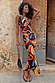 Banana A-Symmetric Top and matching skirt co-ord with vibrant banana motifs on a model against a stone wall.