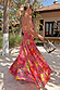 Pink Fruit Stamps Skirt with a Mediterranean fruit print and shirred waistband, worn on a sandy beach vacation.