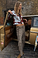 Thumbnail for Leopard Barrel Jeans Petite with a barrel-leg fit and leopard print, styled with a cardigan by a gold vintage car.