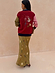 Olive Mystical Dorris Skirt with a celestial print, styled with a red color-block cardigan from behind.