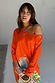 Orange Rio Jem Dress in a relaxed one-shoulder silhouette with a sun and star print, styled with a straw bag.