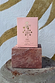 NFD Eau De Parfum 002 pink box with gold foil tropical icons, displayed on a pink marble block.