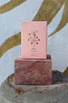 NFD Eau De Parfum 002 pink box with gold foil tropical icons, displayed on a pink marble block.