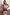 Thumbnail for Lucia Leopard Denim Bag with a wooden handle, held by a model in a vibrant light blue and orange poppy print dress.
