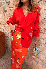 Red Celestial Cardigan featuring embroidered sun and star motifs, styled with a matching printed co-ord skirt.