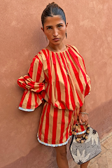 Red and camel Tomato Stripe Blouse with voluminous sleeves and drawstring waist on a model.