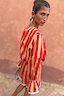 Tomato Stripe Blouse in red and camel striped cotton with voluminous sleeves and flared cuffs on a model.