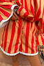 Tomato Stripe Ellie Shorts featuring red and camel stripes, a drawstring waist and blue frill hem.