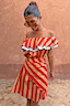 Tomato Stripe Mini Dress in red and camel stripes with a ruffled off-the-shoulder neckline and blue trim.