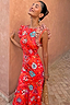 Tomato Tapestry Frida Dress featuring red sun motifs and spot print ruffle sleeves on a model.