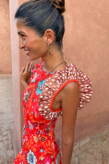 NFD Tomato Tapestry Frida Dress in red with sun motifs, florals and contrasting spot print frill sleeves on a model.