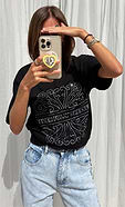 model is taking a selfie wearing the beaded logo black t-shirt with our blue scallop jeans