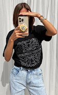 model is taking a selfie wearing the beaded logo black t-shirt with our blue scallop jeans 