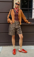 model is wearing the leopard long shorts with the chocolate ribbed tank and camel knit cardigan