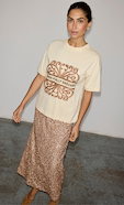 model is wearing the cream logo t-shirt with the gold sequin dorris midi skirt 