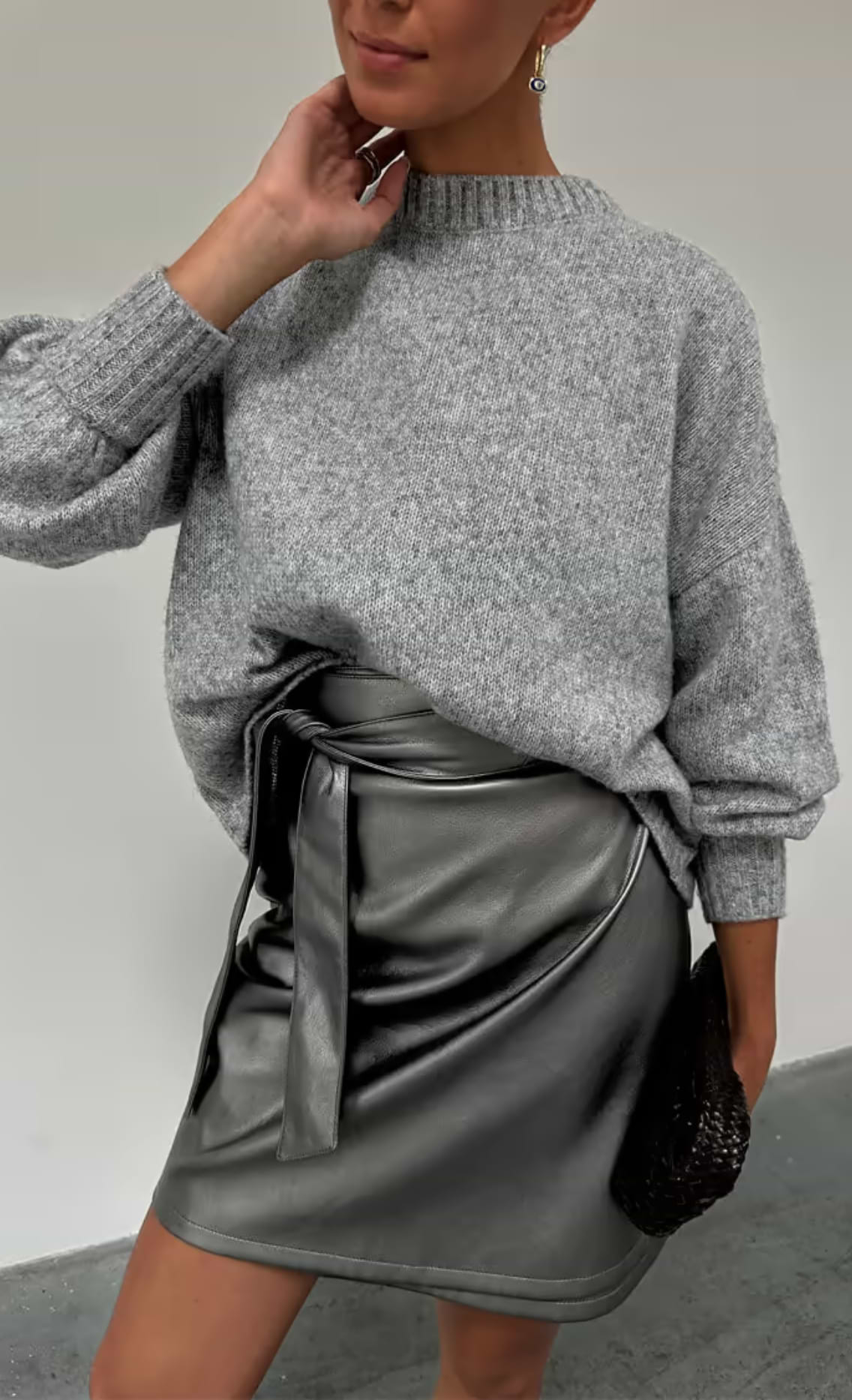 close up of our grey copenhagen knit jumper with the gunmetal vegan leather mini jaspre wrap skirt 