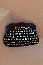 Black Beaded Mirror Bag with geometric mirror shapes and a dark wooden handle, resting on a textured neutral surface.