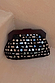 Black Beaded Mirror Bag with geometric mirror shapes and a dark wooden handle, resting on a textured neutral surface.