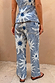 Soleil Jeans in blue denim with oversized sun motifs and wavy lines, shown from the back as a matching co-ord.