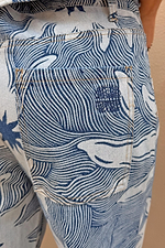 Soleil Jeans back pocket detail featuring a blue and white wavy line print and embroidered sun motif.