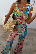 Blue Mari Plisse Trousers and matching top in a vibrant paisley print, styled with a natural woven bag.