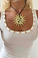 Deloris Sun Necklace featuring a gold sun pendant with semi-precious stones on a black leather cord and white vest top.